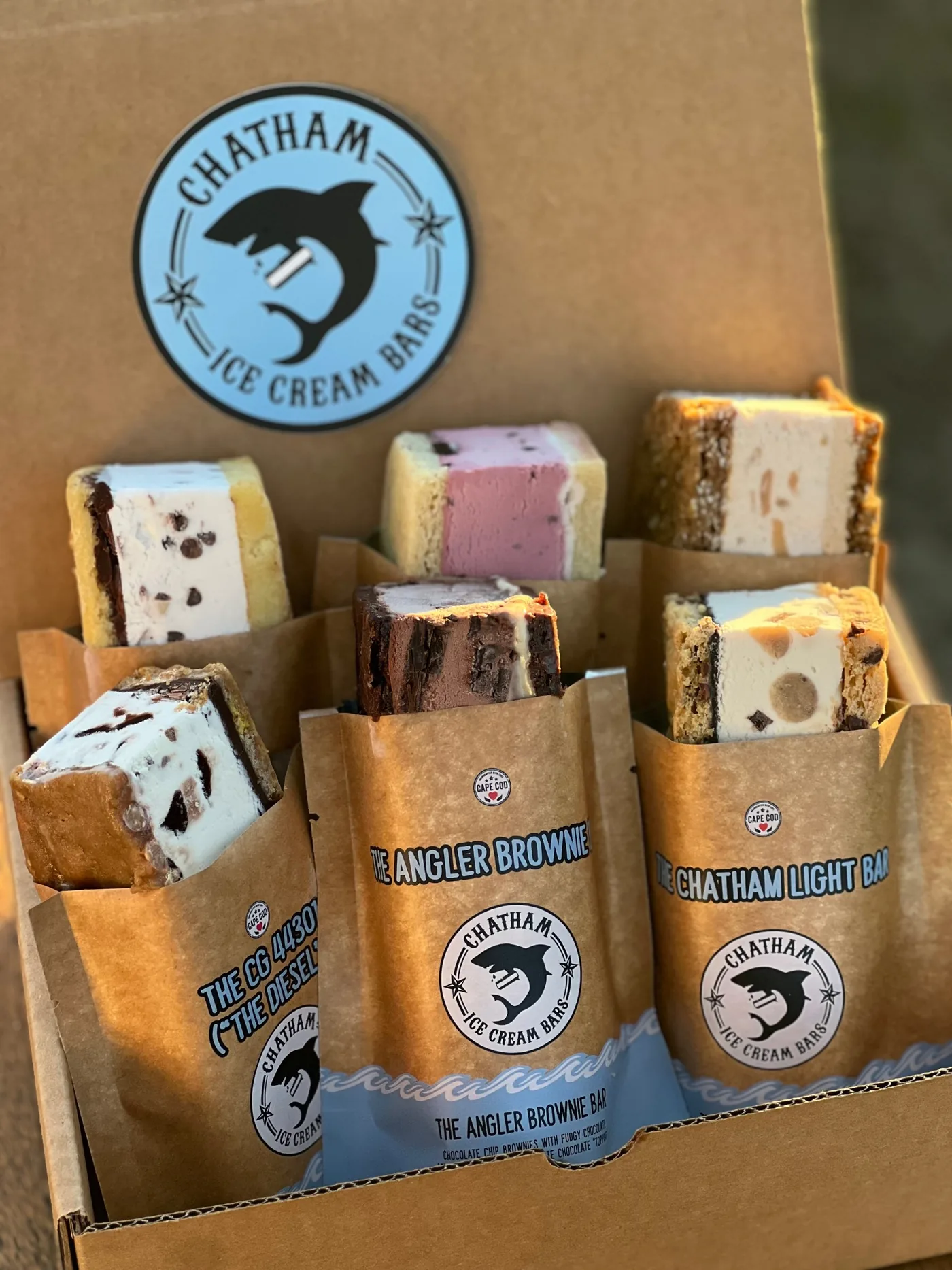 A box of six Chatham Ice Cream Bars in kraft sleeves, lit by the evening sun