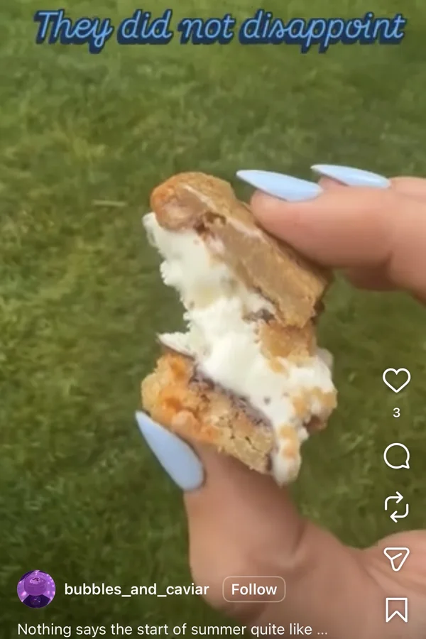 A bitten ice cream bar held up over green grass